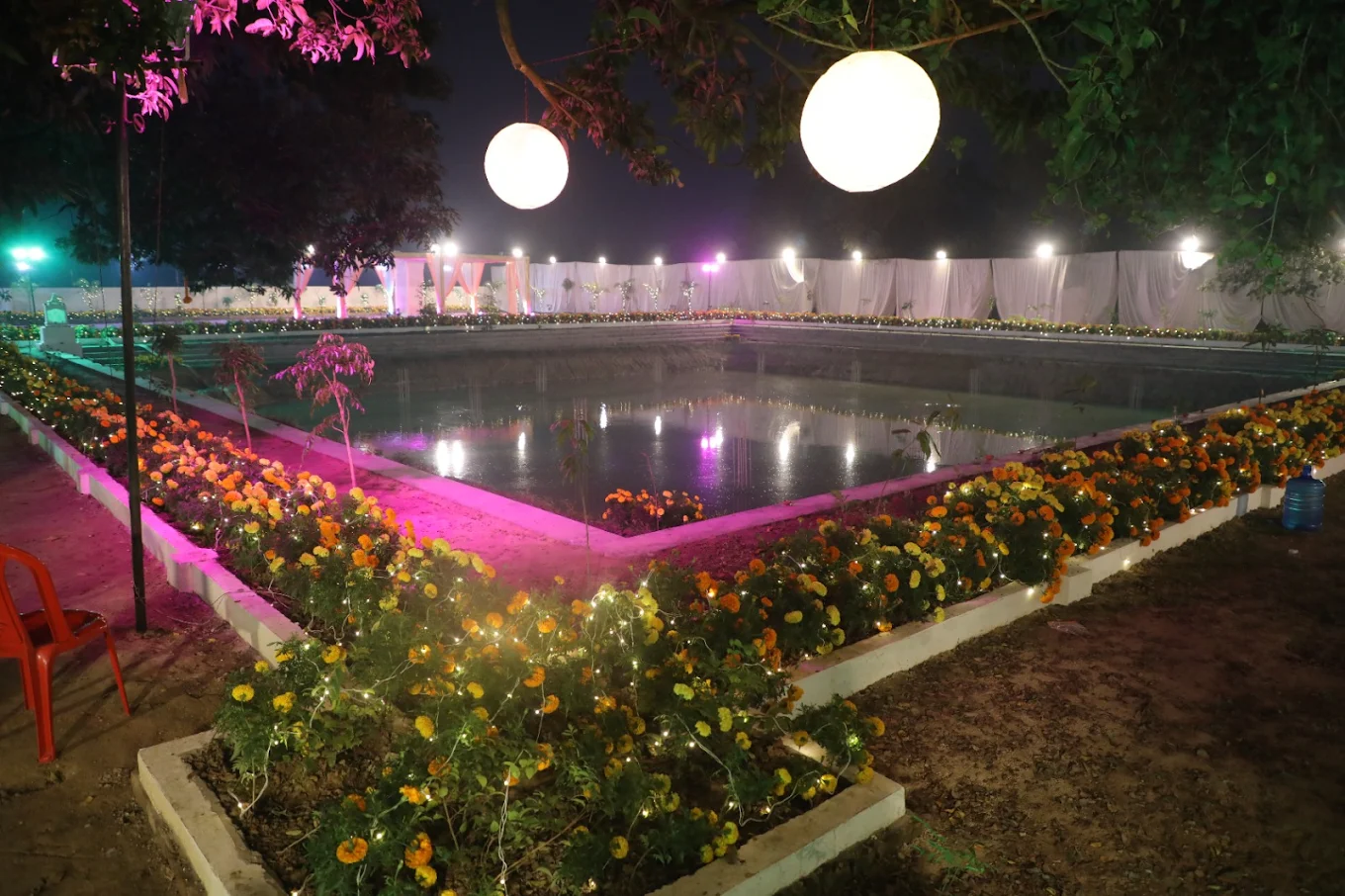 Outdoor event space with water feature and colorful lighting